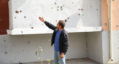 Следы попадания осколков снарядов на стене дома и балконе. Фото Азиза Каримова для "Кавказского узла"