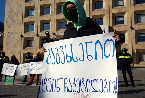 Участник митинга держит плакат с надписью "Вспомните о нас, мозгоизолированные! (негодяи)". Тбилиси, 24 января 2021 года. Фото Беслана Кмузова для "Кавказского узла".