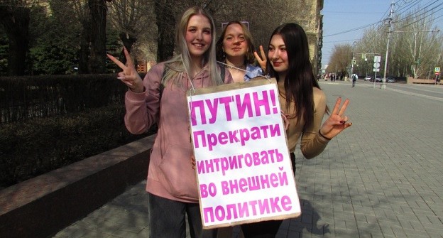 Прохожие фотографируются с плакатом оппозиционеров. Фото Вячеслава Ященко для "Кавказского узла".
