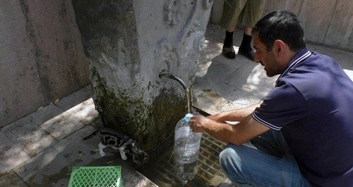 Житель Степанакерта набирает воду из источника. Фото Давида Симоняна для "Кавказского узла".