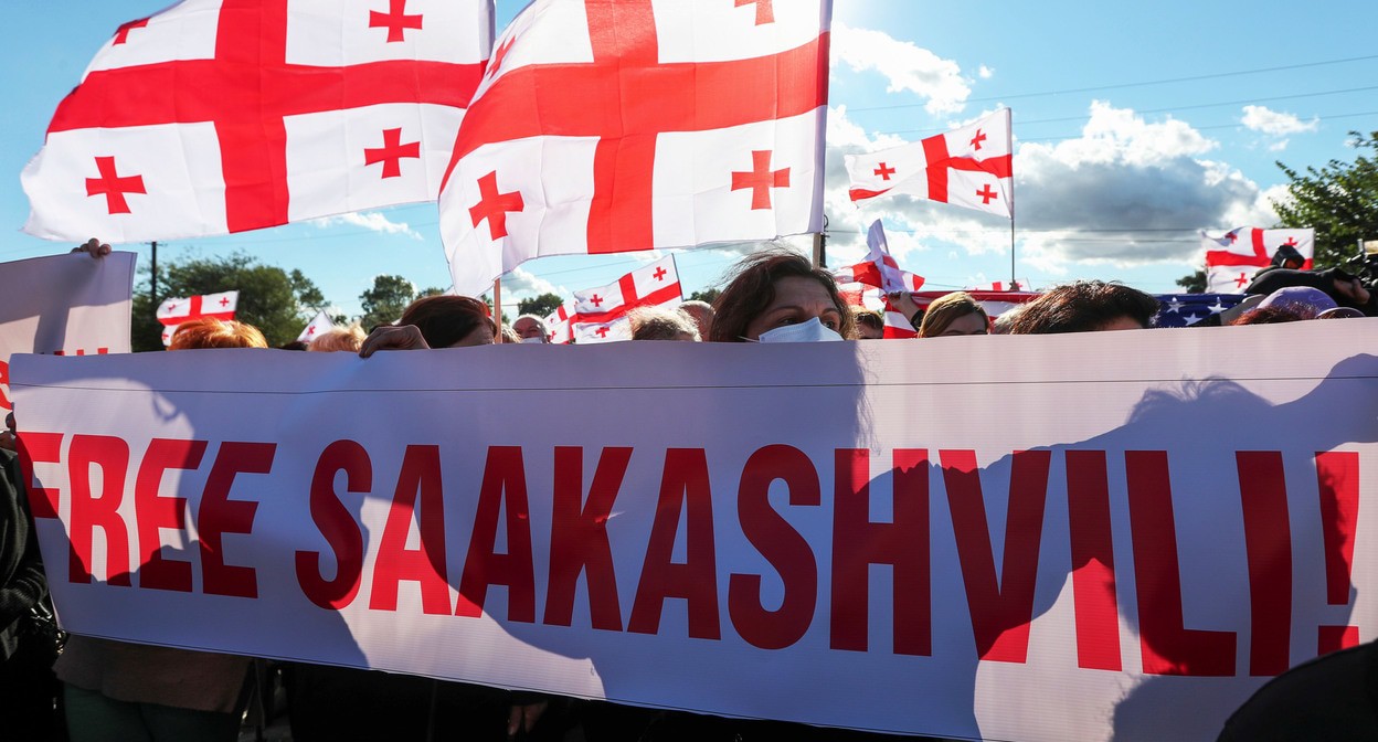 Сторонники Михаила Саакашвили с плакатом и флагами Грузии. 4 октября 2021 года. Фото: REUTERS/Irakli Gedenidze