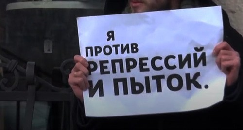 Плакат участника пикета против пыток. Скриншот видео https://www.youtube.com/watch?v=ixWMh8DMok4