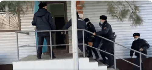 Полицейские заносят в отделение активиста из Григорополисской. 25 ноября 2021 года. Стоп-кадр видео https://twitter.com/asilikedem/status/1463795233196494850