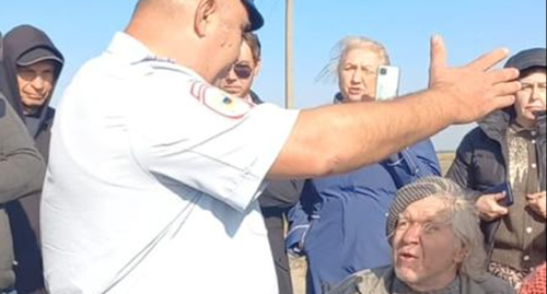 Противники свалки в Полтавской беседуют с полицейским. Фото: тг-канал "Полтавская против свалки"