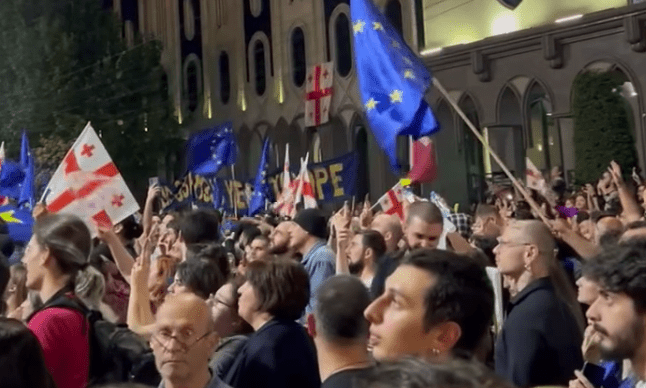 Флаги ЕС и Грузии на акции против закона об иноагентах. Стоп-кадр видео Paper Kartuli от 28.04.24, https://t.me/paperkartuli/12314
