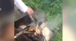 Молодой человек кладет в разведенный в мангале огонь Новый Завет. Стоп-кадр видео управления СКР по Ставрополью от 03.05.24, https://t.me/su_skr26/3115
