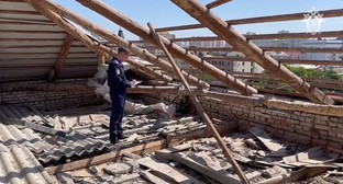 Сотрудник Следственного комитета осматривает крышу школы в Краснодаре, с которой сильный ветер сорвал кровлю. Кадр из видео https://vk.com/wall-49878783_231513