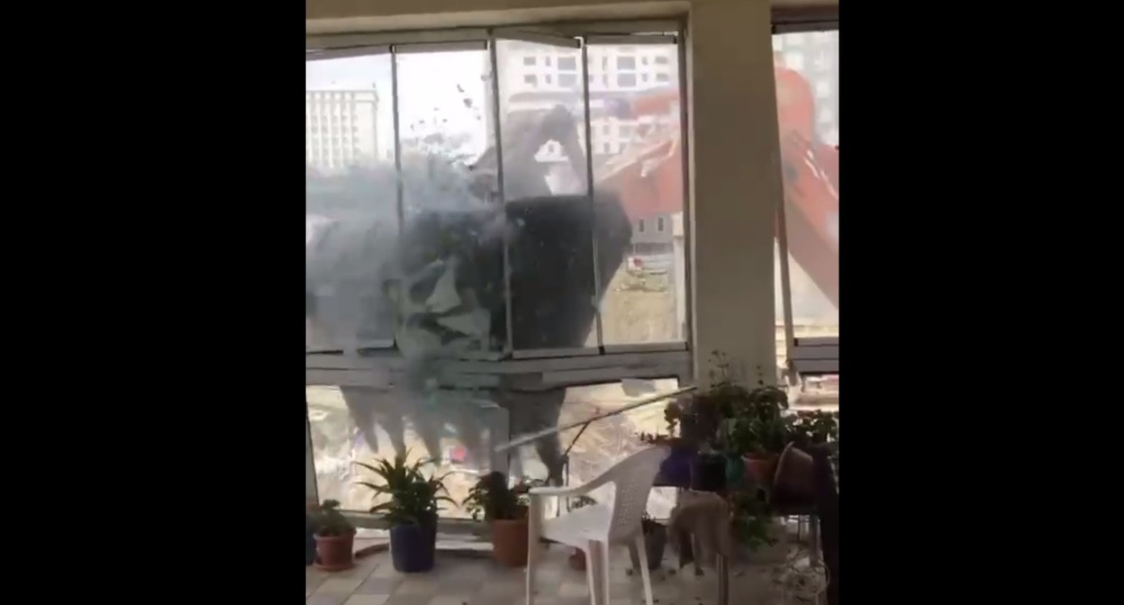 Водитель экскаватора разрушает фасад дома Элары Гаджиевой. Кадр видео, снятого очевидцами и опубликованного в телеграм-канале JAMnews https://t.me/jamnewsru/22978