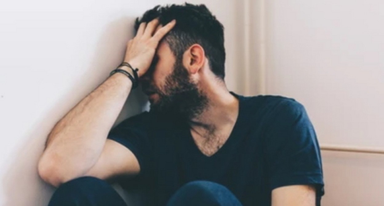 Пациент клиники лечения зависимости, фото: https://www.shutterstock.com/ru/image-photo/sad-young-man-sitting-corner-room-474370996