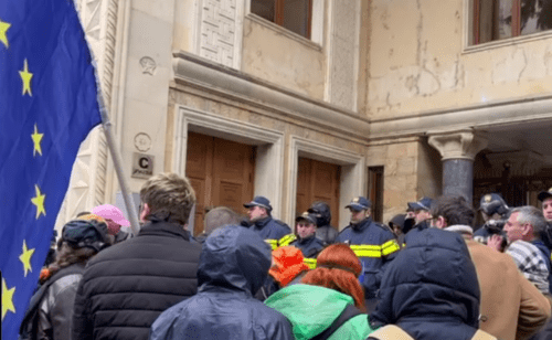 Протестующие и силовики у заднего входа в парламент Грузии. Стоп-кадр видео Tbilisi Life от 12.04.25, https://t.me/Tbilisi_life/38858.
