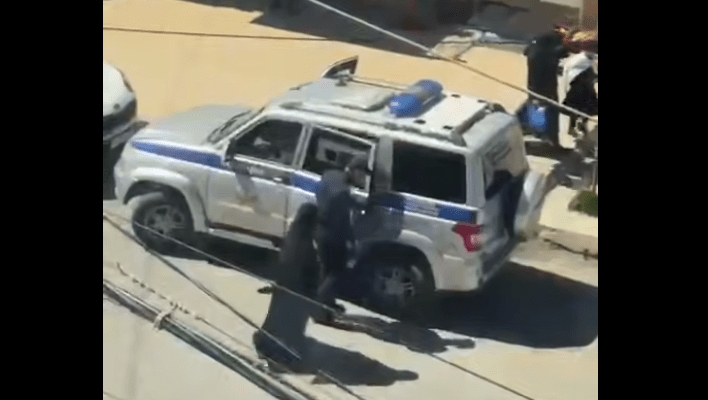 Силовик сажает мусульманку в машину. Стоп-кадр видео из Telegram-канала "Совесть Дагестана" от 20.04.25, https://t.me/sovestdagestana/38592