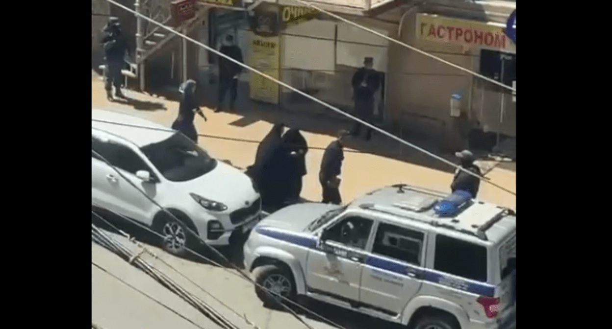 Девушки в никабах у полицейской машины. Стоп-кадр видео из Telegram-канала "Совесть Дагестана" от 20.04.25, https://t.me/sovestdagestana/38592?single