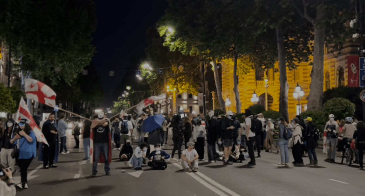 Активисты заблокировали движение у театра оперы и балета. Скриншот фото телекомпании "Пирвели" от 24.05.25, https://tvpirveli.ge/ka/siaxleebi/politika/101879-politsiam-rustaveli-chaketa-aqtivistebma-operis-tsin-gadainatsvles.