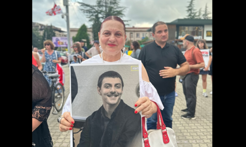 Женщина с портретом Сабы Джикия в Зугдиди. Скриншот фото Publika от 12.07.25, https://www.facebook.com/photo/?fbid=1494712685261610&set=pb.100041686795244.-2207520000 (деятельность компании Meta, владеющей соцсетью, запрещена в России).