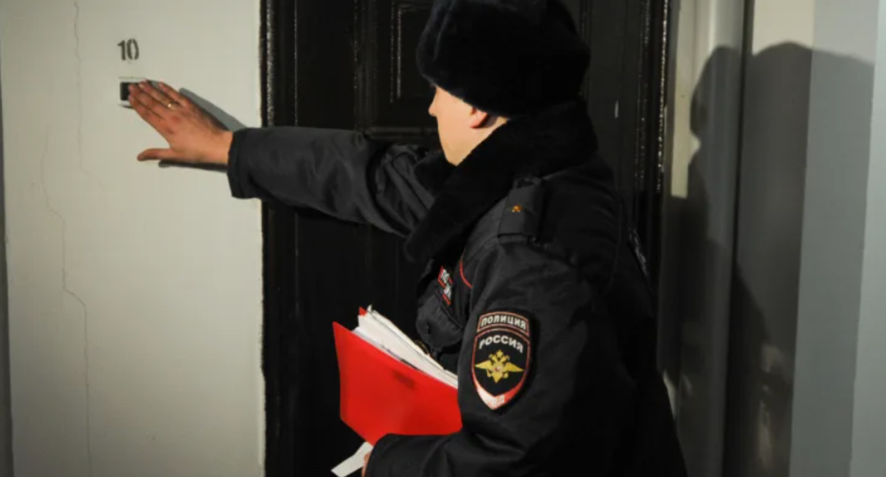 Сотрудник полиции звонит в дверь. Стоп-кадр видео https://www.5-tv.ru/player/458191.