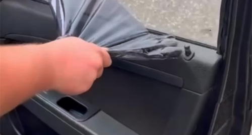 Сотрудник силовых структур снимает тонировку со стекла автомобиля. 24 ноября 2025 г. Скриншот видео https://www.instagram.com/p/DRboa83jCxk/ принадлежит компании Meta деятельность которой запрещена в России