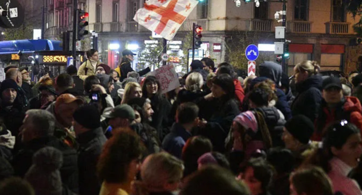 Участники акции протеста в Тбилиси. Скриншот фото "Интерпрессньюс" от 06.12.25, https://www.interpressnews.ge/ru/article/172142-prokhodit-aktsiia-shestvie-pod-devizom-rezhim-nas-otravliaet-dolzhno-byt-provedeno-mezhdunarodnoe-rassledovanie