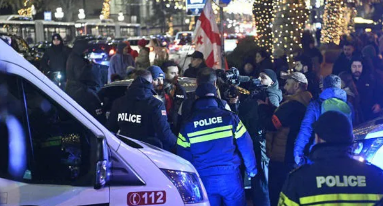 Задержание Давида Асанидзе. Скриншот фото "Интерпрессньюс" от 17.12.25, https://www.interpressnews.ge/ka/article/857612-kashvetis-mimdebared-policiam-akciis-ert-erti-monacile-daakava