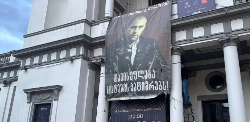 Баннер в поддержку Андро Чичинадзе. Скриншот фото "Новости Грузия" от 21.02.26, https://www.newsgeorgia.ge/aktery-novogo-teatra-pokidajut-truppu-posle-snjatija-bannera-v-podderzhku-andro-chichinadze/