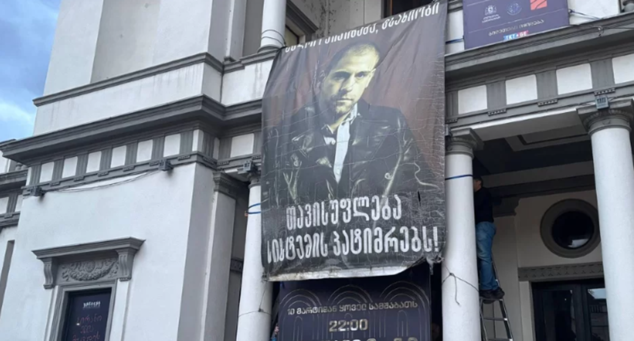 Баннер в поддержку Андро Чичинадзе. Скриншот фото "Новости Грузия" от 21.02.26, https://www.newsgeorgia.ge/aktery-novogo-teatra-pokidajut-truppu-posle-snjatija-bannera-v-podderzhku-andro-chichinadze/
