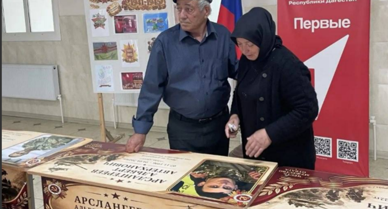 Родные на открытии именной парты. Скриншот фото администрации Бабаюртовского района от 25.05.26, https://t.me/babayurtrayon/12221?single Родные на открытии именной парты. Скриншот фото администрации Бабаюртовского района от 25.05.26, https://t.me/babayurtrayon/12221?single