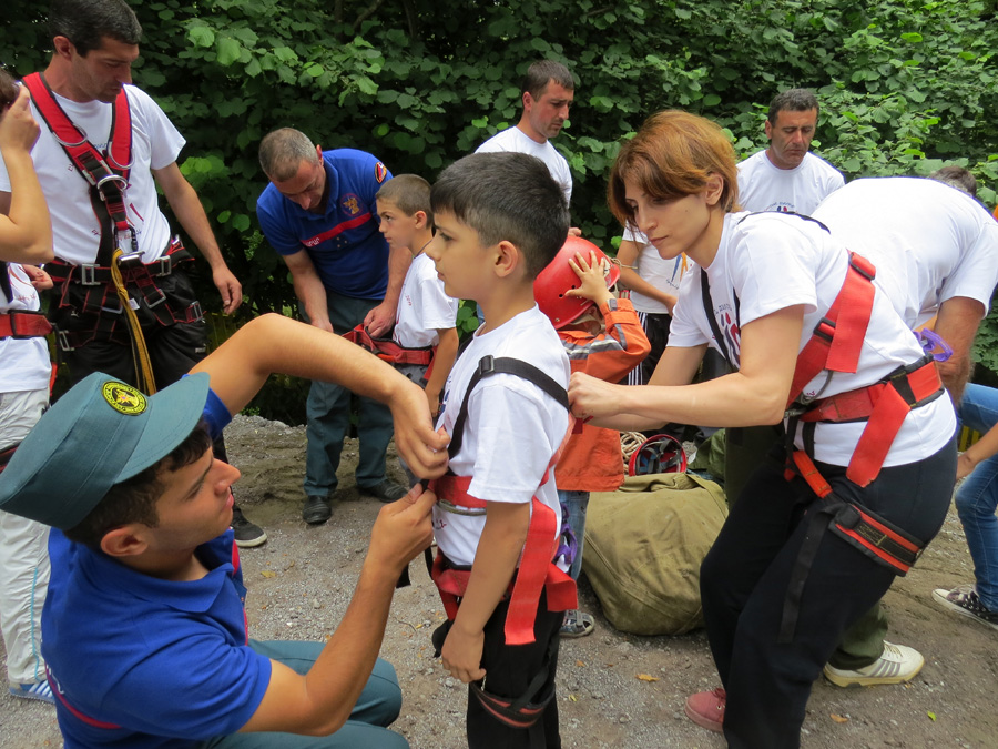 Для перестраховки, мать помогает надеть сынишке туристическое снаряжение.