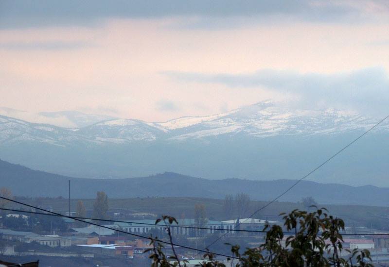 В близлежащих горах уже ложится снег.