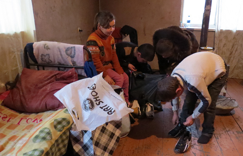 Увидев пакеты с  вещами, дети налетели и начвали разбирать их, примерять...