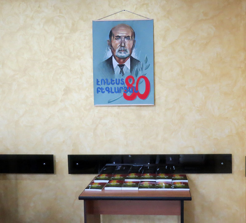 Плакат с изображением Эрнеста Бегларяна. На столике книга "Я ещё живой".